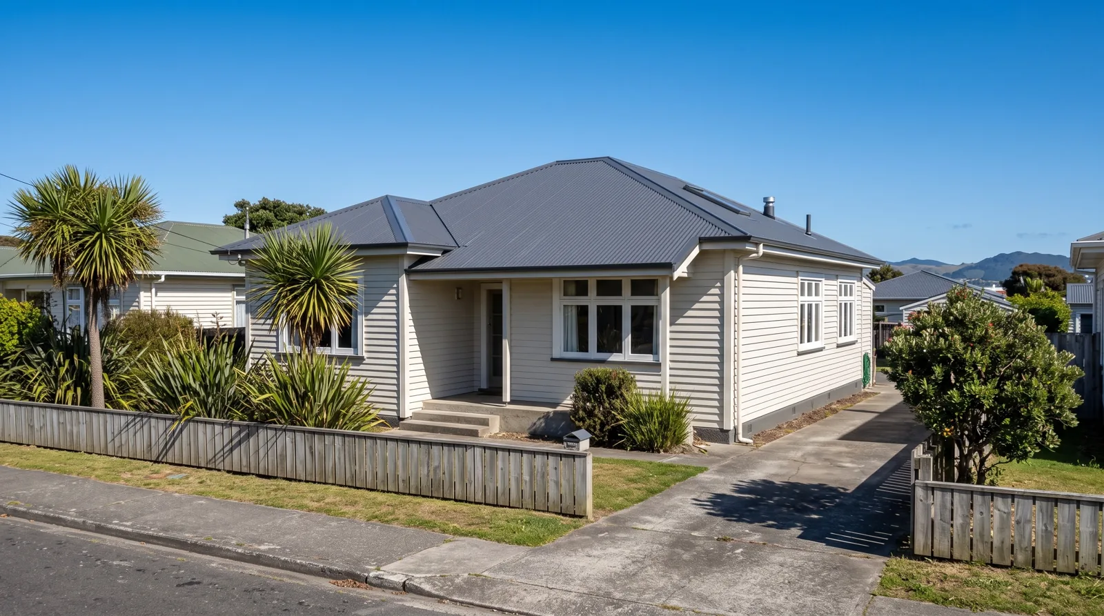 After: the same weatherboard bungalow with a new charcoal Colorsteel roof